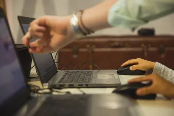 Teacher and student working on laptop