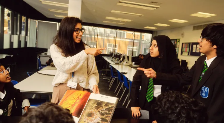 Teacher with students looking at science book